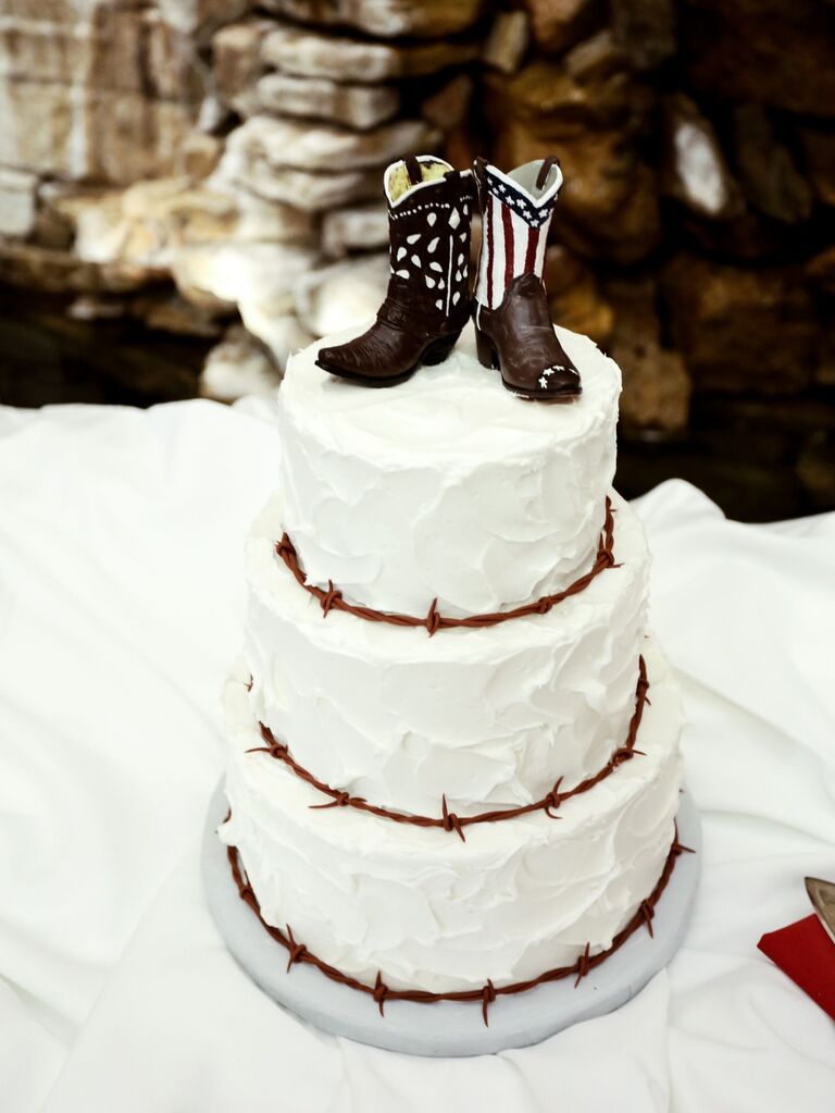 White wedding cake topped with rustic cowboy boot topper. 