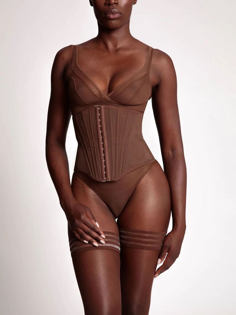 Model wearing wedding corset undergarment in dark nude hue