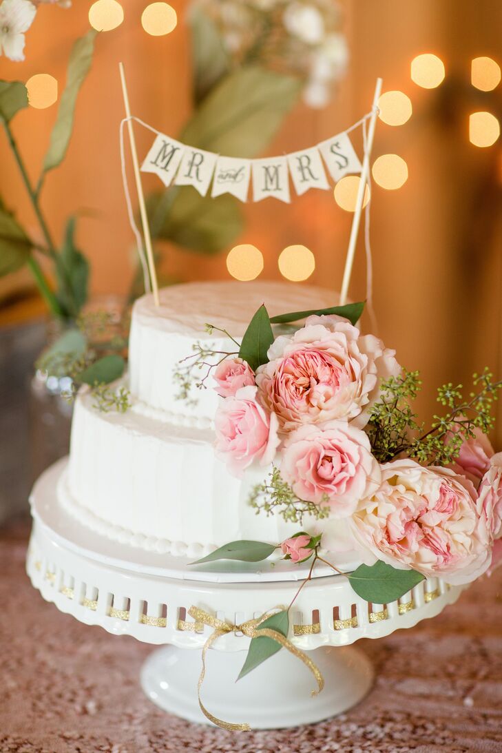 The small, two tiered cake was decorated with fresh flowers and featured a small Mr and Mrs bunting cake topper.