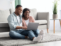 Couple similing while looking at a computer.