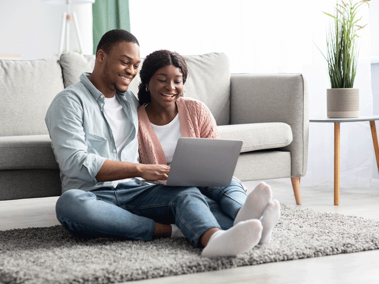 Couple similing while looking at a computer.