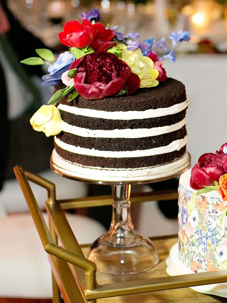 one tier chocolate naked wedding cake decorated with red, yellow and blue flowers on top