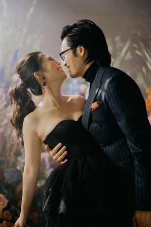 Bride in Black Wedding Dress With Ponytail Hugging Groom