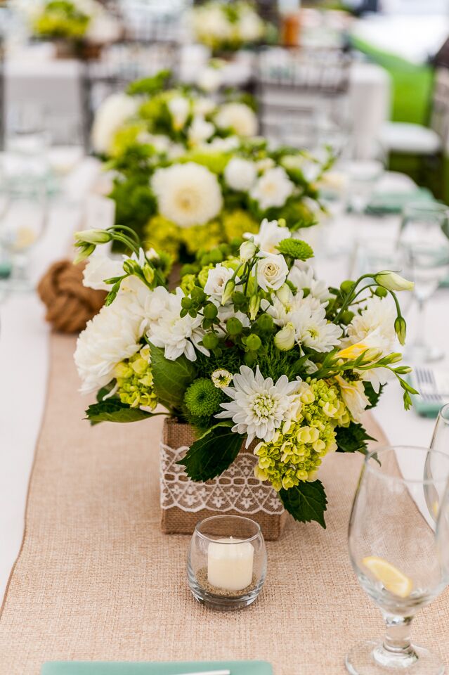 The bride wanted to create eclectic centerpieces based on colors she liked. Although the bride and groom had a nautical theme, they incorporated green, white and yellow into their floral arrangements to keep the color palette feeling classic and fresh.