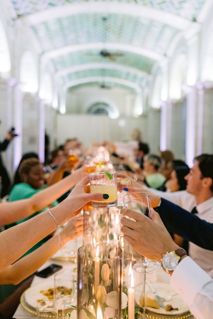 Guests at Long Dining Table Toasting With Others Across the Table, Signature Cocktails