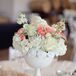 Flower arrangements of roses and stock with touches of astilbes, baby's breath and veronica decorated each dining table.