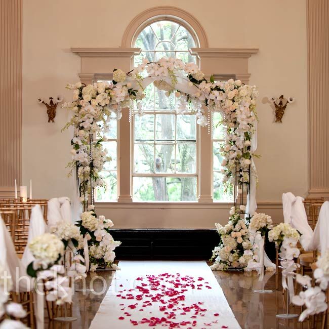 The focal point of the indoor ceremony was an arbor covered in all-white flowers and crystals.