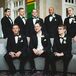 The groomsmen looked dapper in black Calvin Klein two-button tuxedos that they accessorized with black vests and bow ties.