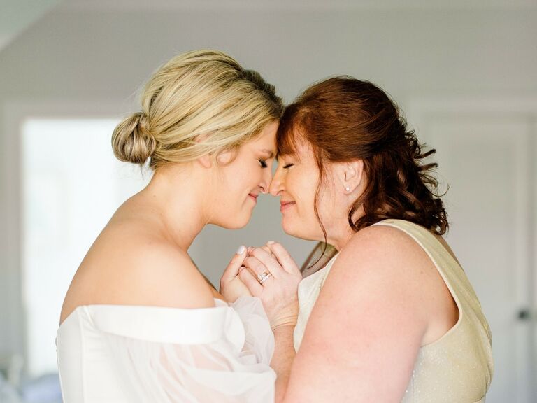 Bride and her mother embrace joyfully. 