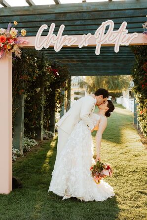 Groom Dips Bride in a Kiss Under Custom Welcome Arch at Retro Desert Wedding