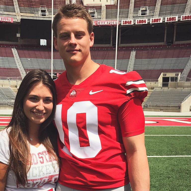 Oliva and Joe smile on the football field at OSU. 