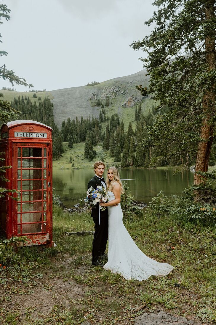Groom in Tuxedo and Bride in Fitted Lace Gown With Wildflower Bouquet and British Phone Booth