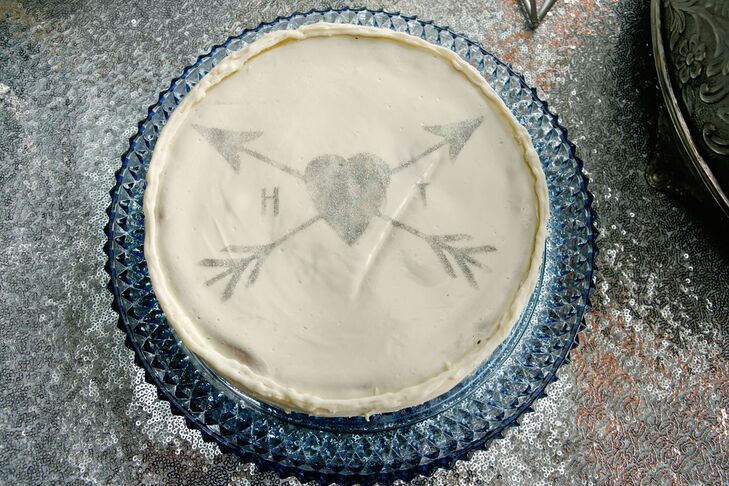 Instead of a traditional groom’s cake, the couple ordered three cheesecakes from Stregare Cheesecake and decorated them with stencils to match the crossed-arrow wedding logo.