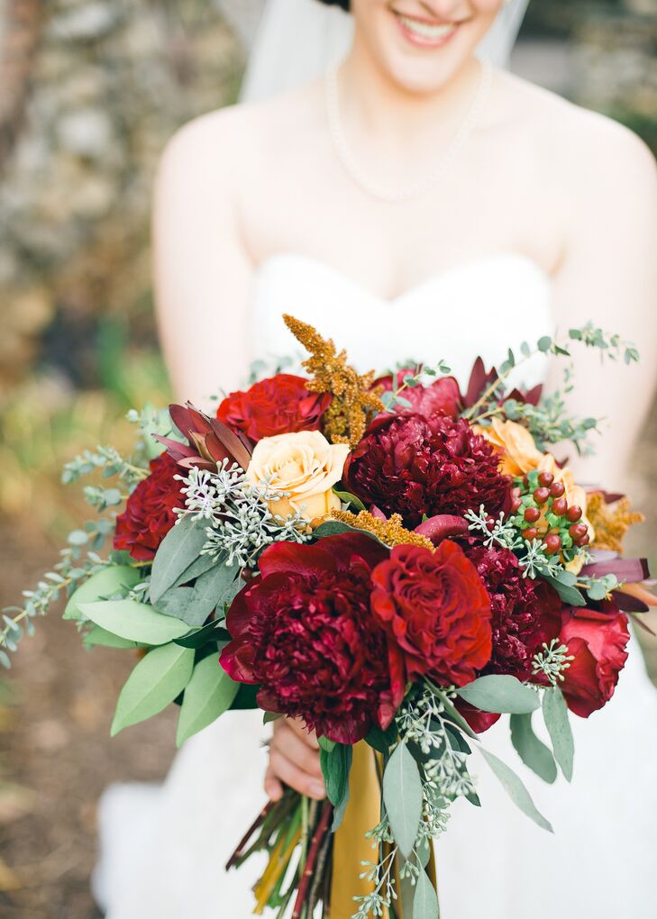 Ellie's bridal bouquet was filled with dark red and yellow roses, hypericum berries and eucalyptus.