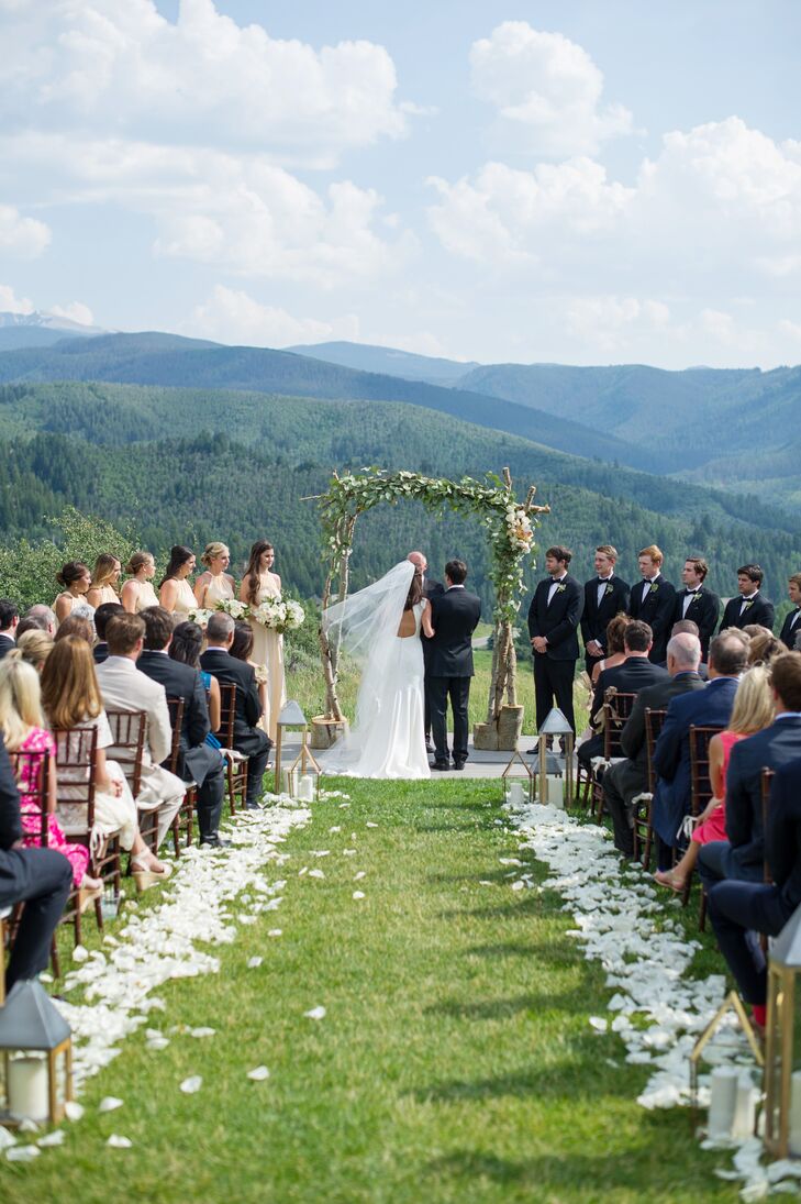 The couple lined their ceremony aisle with white rose petals, small gold lanterns and candles for a romantic flair.