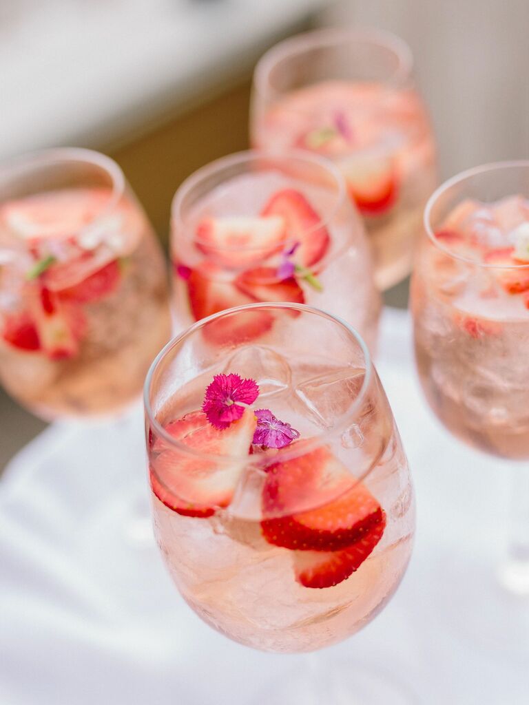 wedding cocktails with fresh strawberries and magenta flowers as garnish