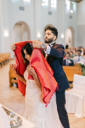 Groom Placing the Red Mathrakodi Over His Bride's Head During Knanaya Indian Christian Ceremony