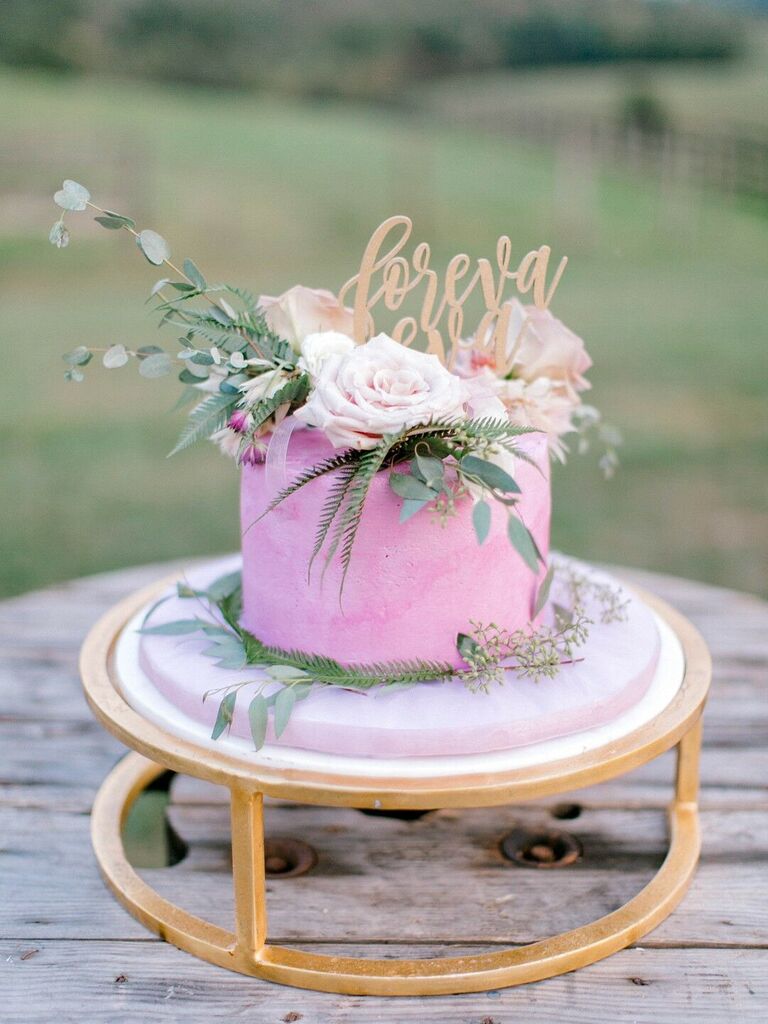 purple one tier wedding cake on gold stand with roses and greenery