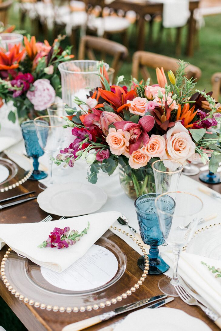 Vintage Blue Glassware and Bright Floral Arrangements on Wedding Reception Tables