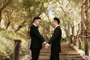 Grooms in Classic Tuxedo Holding Hands on Long, Outdoor Staircase With Trees