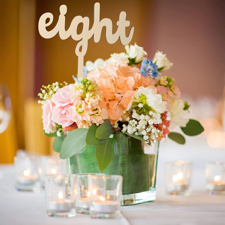 wooden rustic wedding table number with cursive writing on a stick