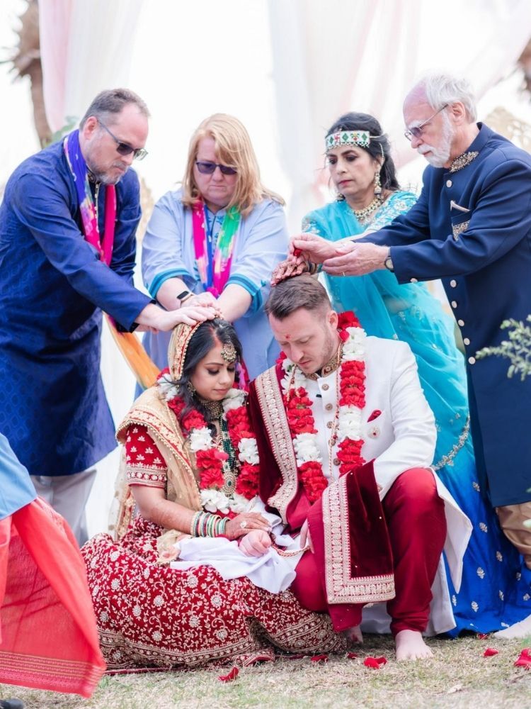 Couple receiving parents' blessing during Hindu wedding ceremony