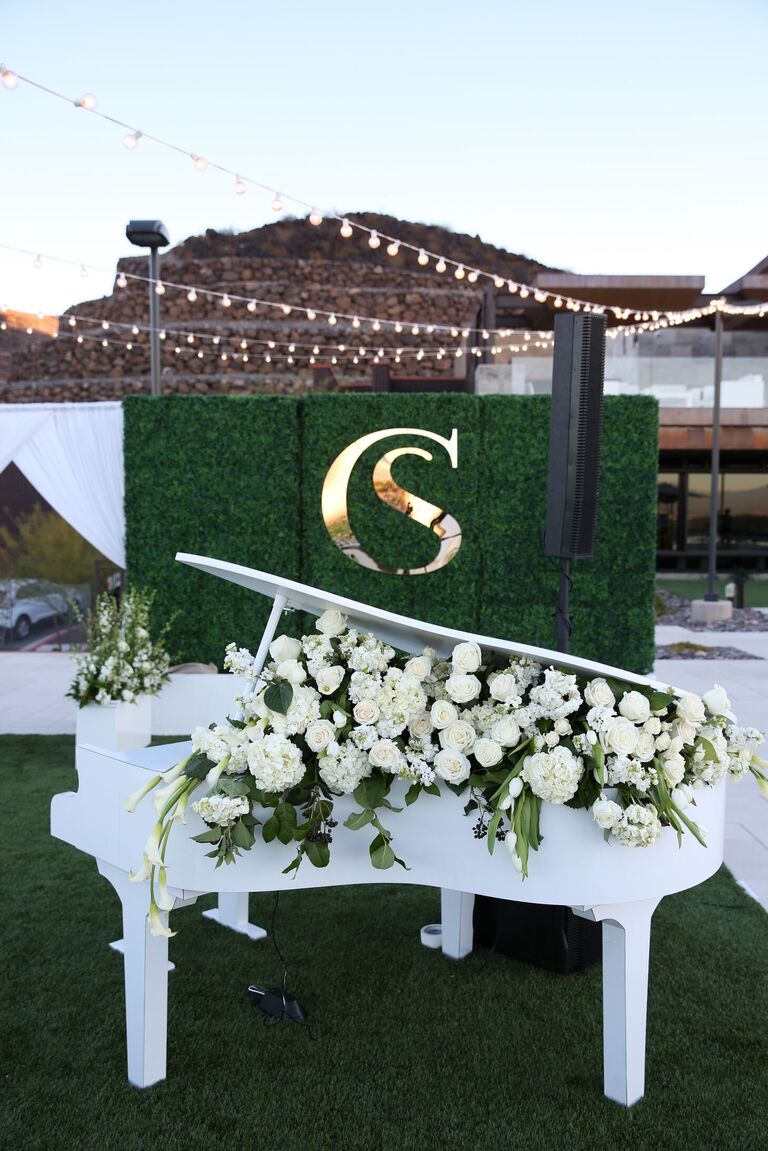 White piano filled with white roses, hydrangea and calla lilies 