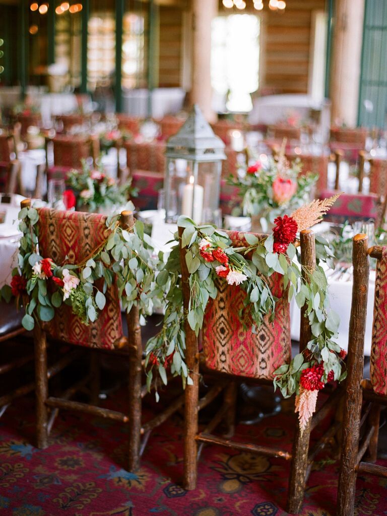 red patterned chairs at long banquet table decorated with eucalyptus garlands