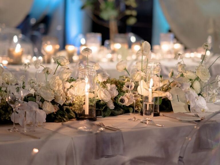 white floral centerpiece with short taper candles