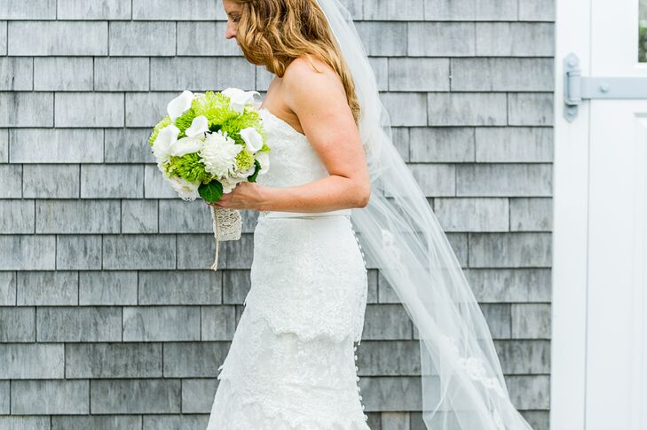 The bride wanted a simple lace dress, and fell in love with this strapless tiered lace gown from J.Crew with a sweetheart neckline. She paired it with a long veil and nude strappy heels.