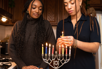 Two Jewish Women Lighting Menorah During Hanukkah Celebration