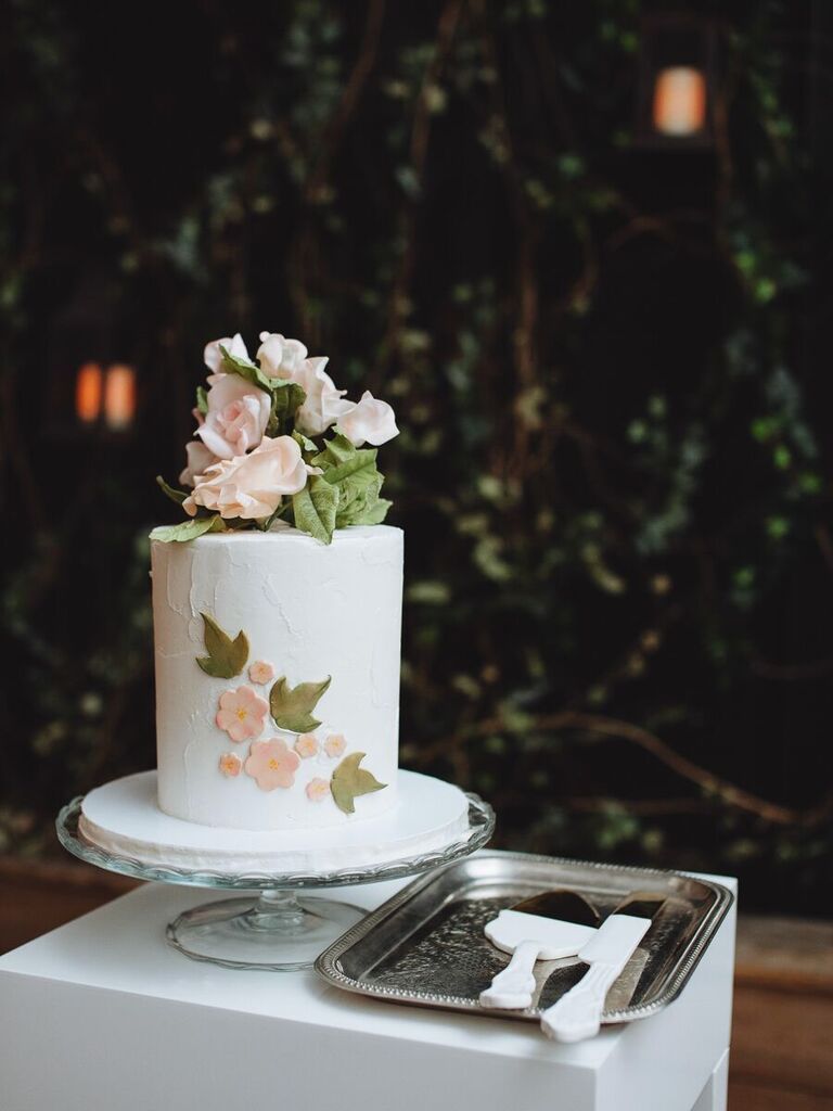 one tier wedding cake with pink sugar flowers and green ivy leaves