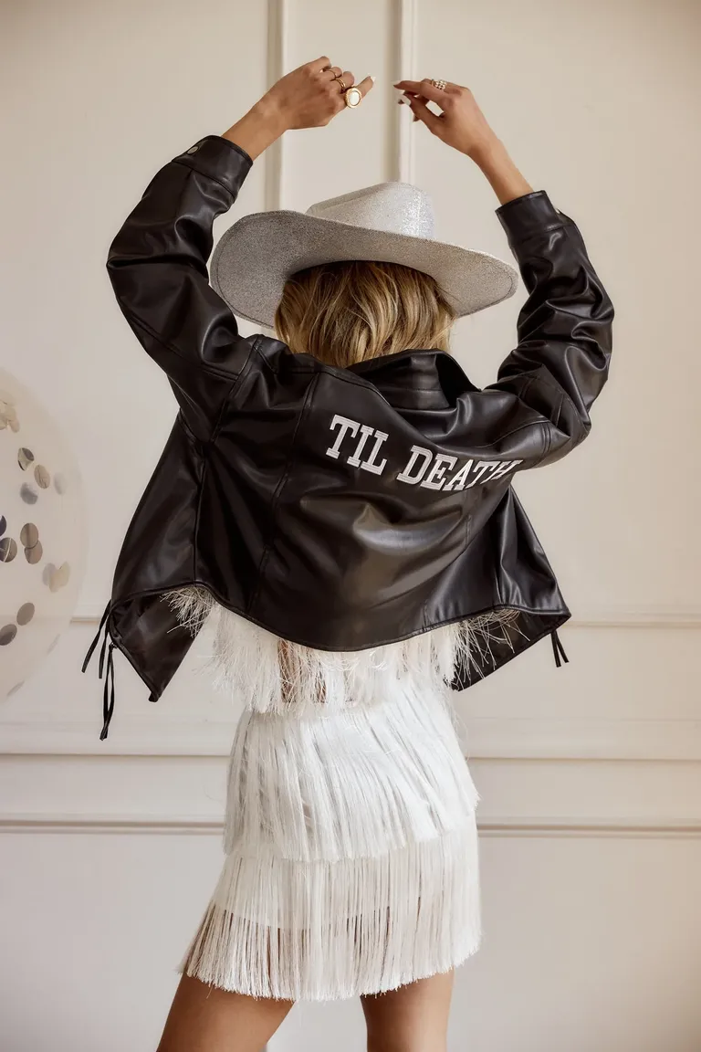 black leather jacket with fringe and 'til death' in white across back
