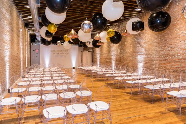 Indoor Ceremony Site with Brick Walls, Balloons and Ghost Chairs