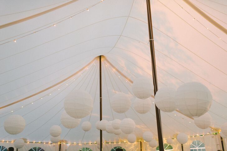An array of white paper lanterns made up interesting lighting at the top of the pitched reception tent. A good replacement for the typical chandelier.