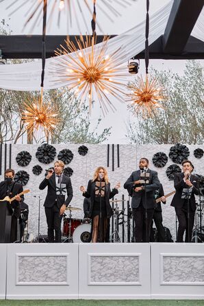 Live Band Performing on Black-and-White Stage With Starburst Chandeliers