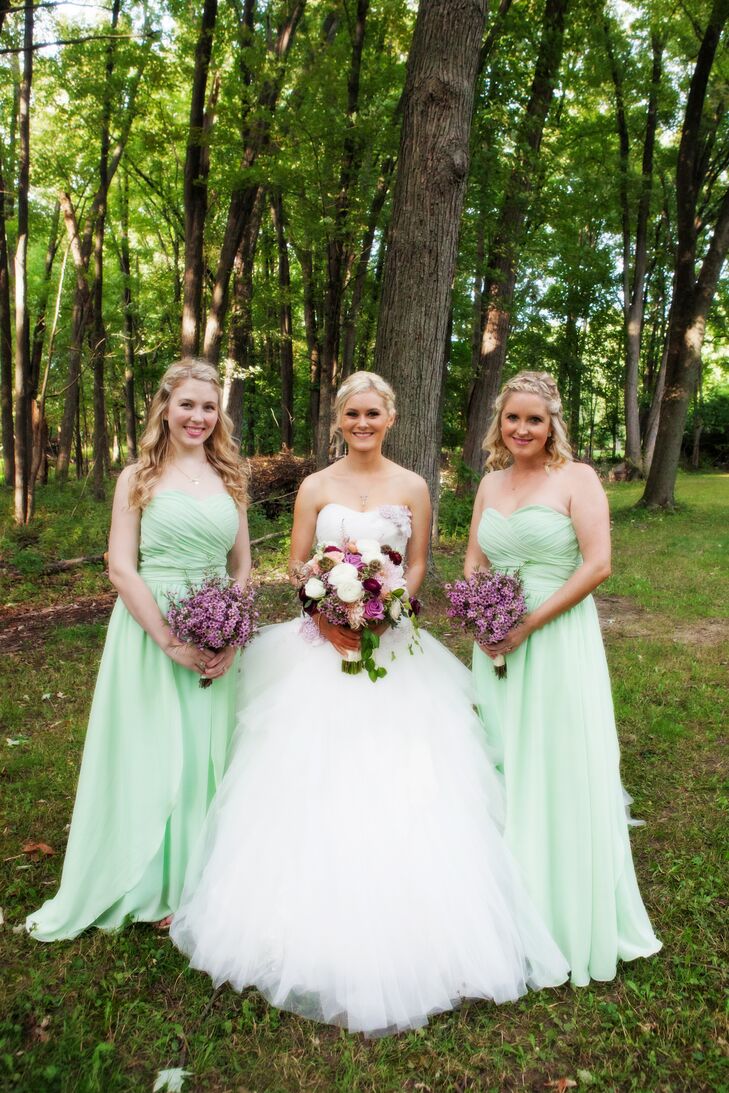 Bridesmaids wore strapless, floor-length mint dresses with a champagne-colored heel. Each carried a bouquet of purple wax flowers at the couple's wedding in Rochester Hills, Michigan.