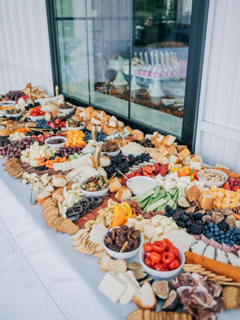Grazing table at a wedding with lots of fruit, meat, and cheese.