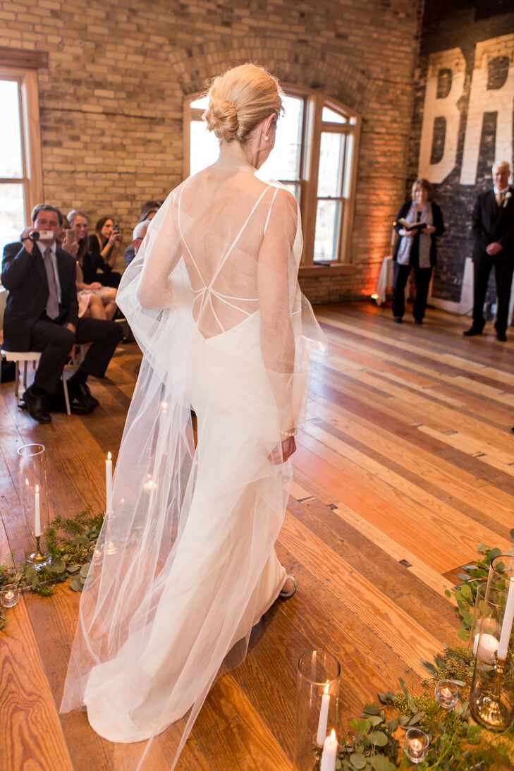 Katherine's gown featured delicate straps and an open back. She wore a sheer shawl. The aisle was lined with eucalyptus leaves, tree branches and candles.