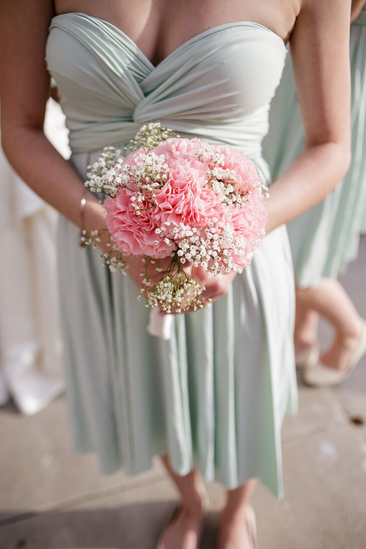The bridesmaids held bouquets filled with pink carnations and baby's breath, with white cloth wrapped around the stems. They added a pop of soft color to the already soft mint bridesmaid dresses.