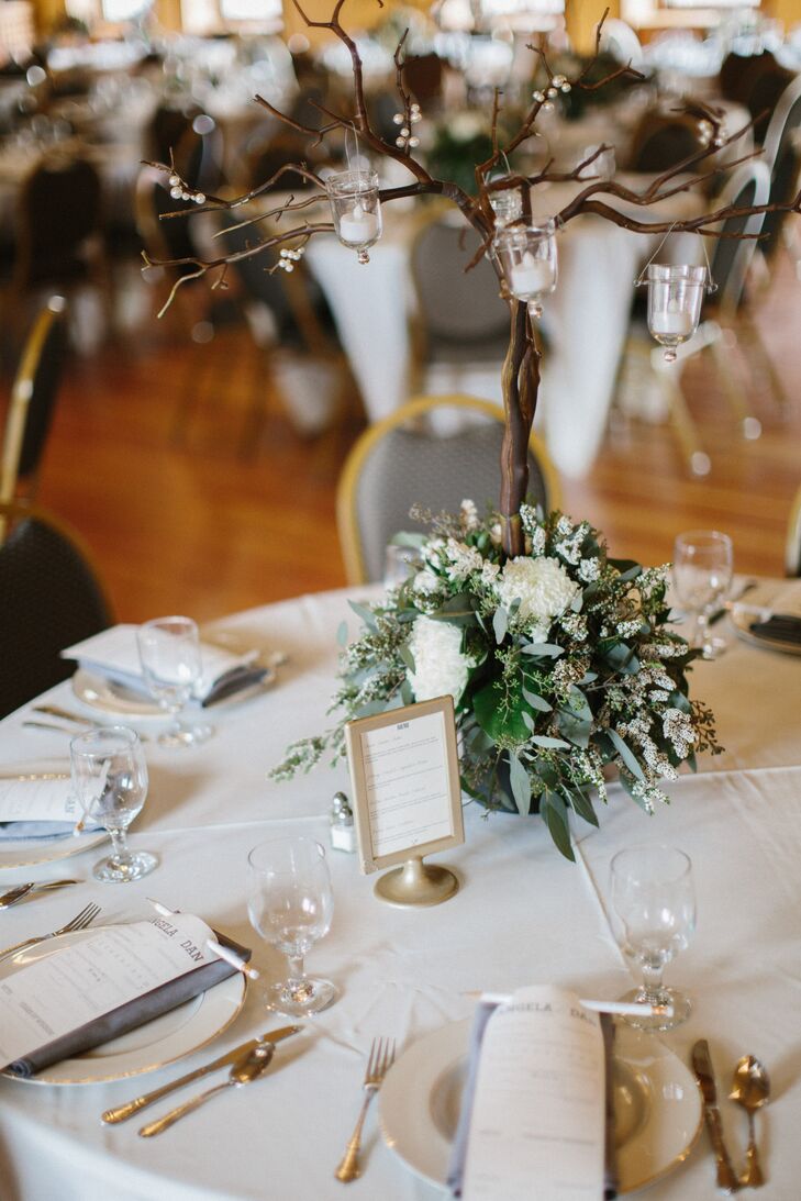 Reception centerpieces included fresh greens and ivory flowers with small votive candles hanging from manzanita branches. Vintage menu holders were placed at every table.
