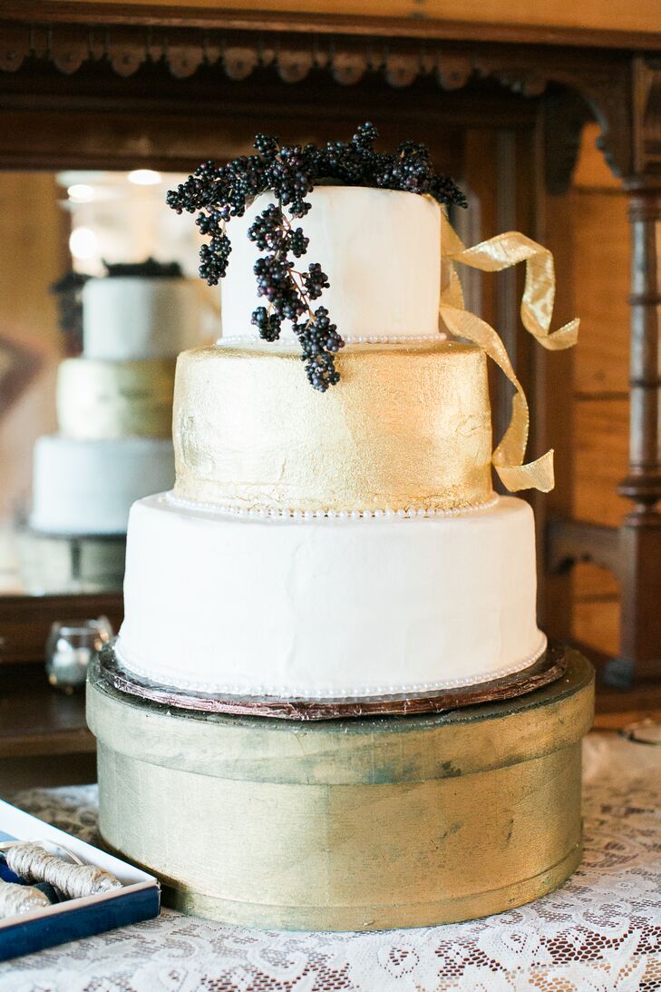 Erica wanted their wedding cake to have a touch of gold, just like her dress. Sherry Moriarty of Cakelady & Company created a jaw-dropping three-tier cake with a gold center tier and gold ribbon details topped with dark blue berries.