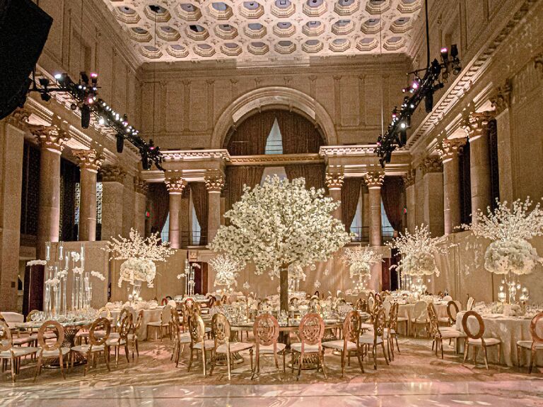 Lavish tall white centerpieces in glam ballroom wedding venue