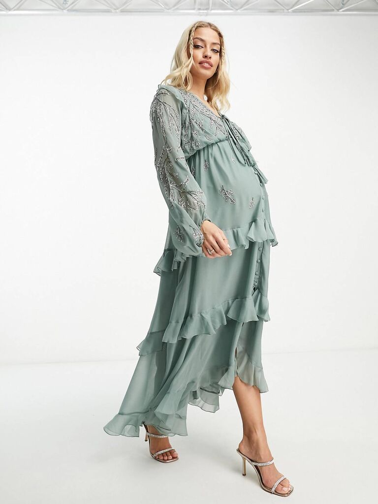 Model wears a sage green bohemian maternity dress. 