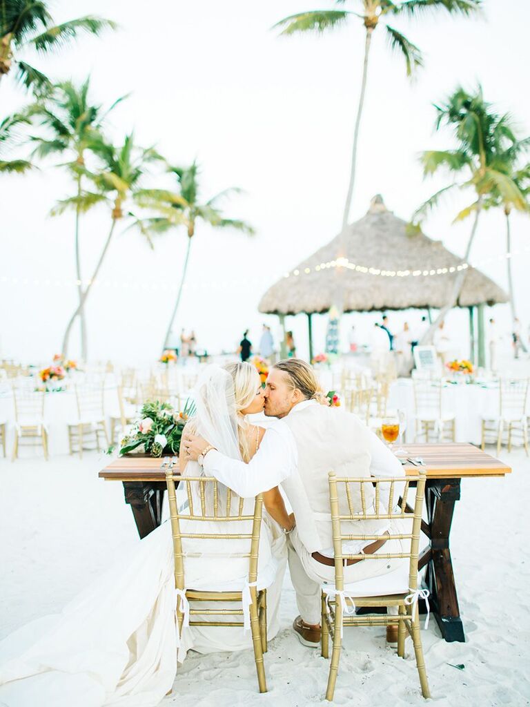 bride and groom kissing on the beach beach reception