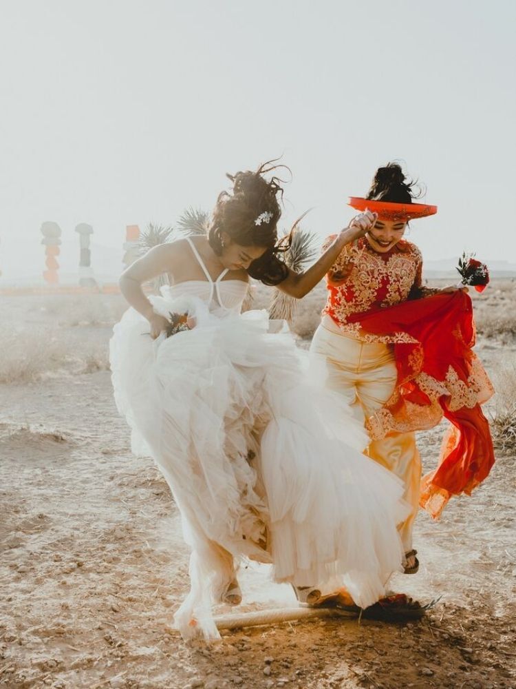 couple jumping broom during wedding