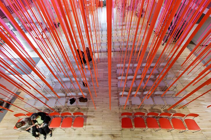 The Children's Museum of Pittsburgh had a colorful mix of fuchsia and orange streamers hanging from the ceiling, right above where the couple had their wedding ceremony.