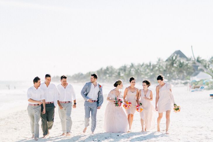 The bridesmaids wore blush and neutral gowns to match the romantic, beachy theme, and the groomsmen dressed in gray pants and white suits with red and pink belts from Beltology. (Since the wedding took place on the sand, everyone went barefoot.)