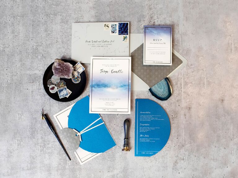 Blue and white celestial-themed wedding invitation suite flat lay
