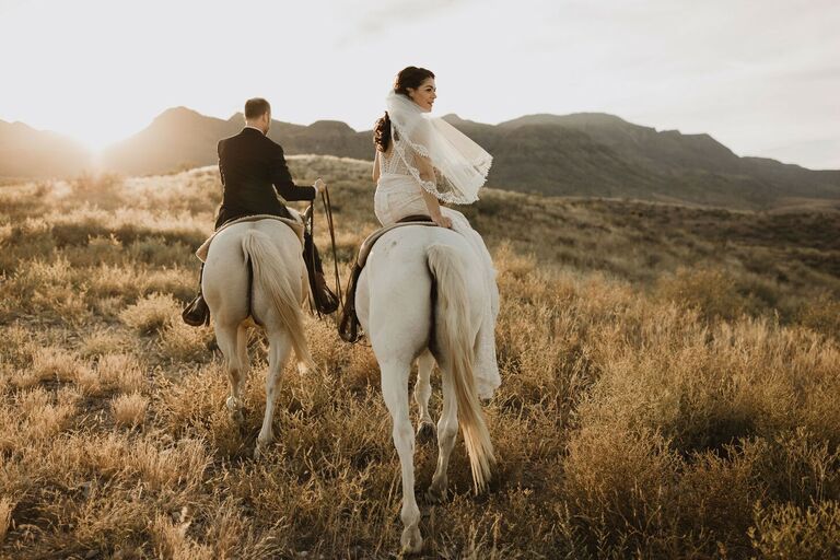 Couple riding away on horse during sunset